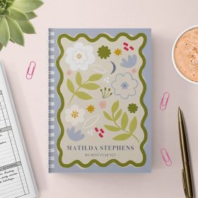 Floral panel diary with a gold pen and cup of hot chocolate on a pink background