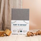 Pregnancy Journal and baby's first year keepsake book standing on table surrounded by wooden toys.